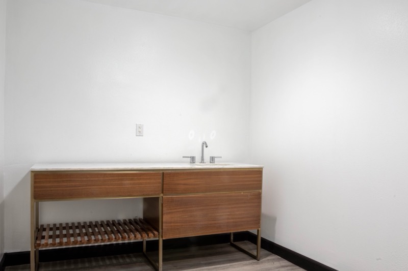 Inside the private suite: marble-topped vanity with a walnut cabinet and gold frame