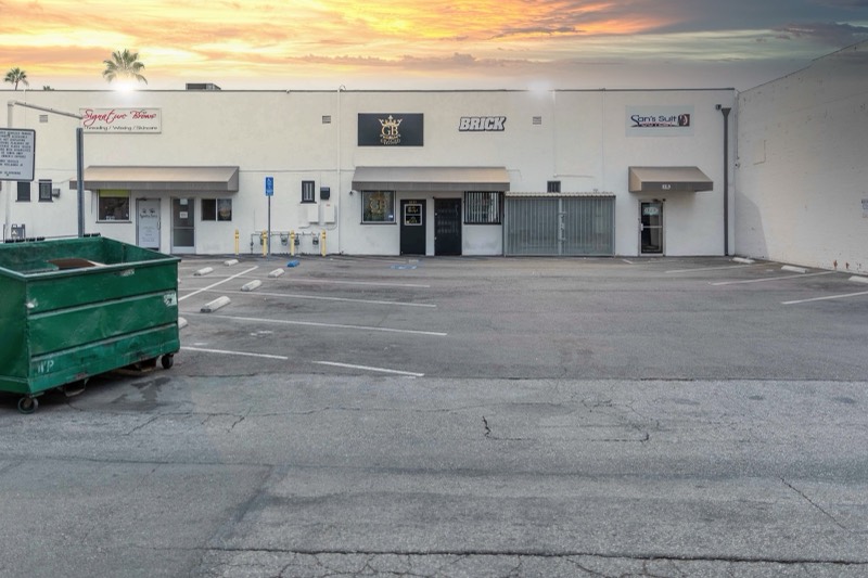 The parking lot behind the salon at sunset, with the gold GB sign on the white building